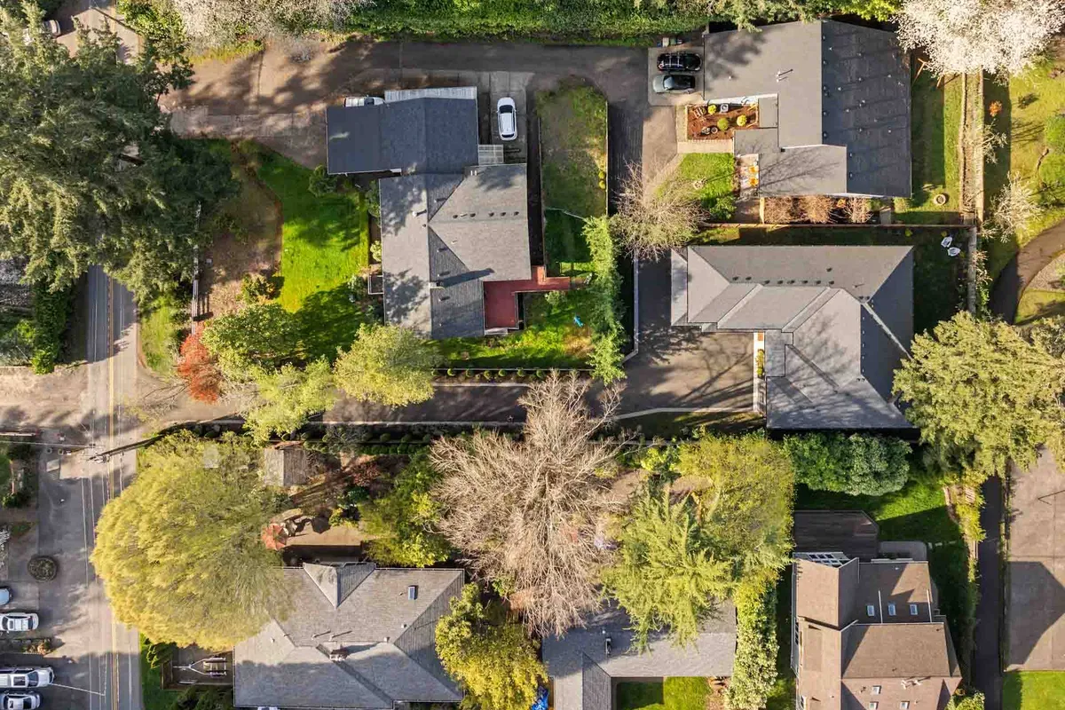 A picturesque streetscape featuring neatly arranged houses surrounded by lush greenery and tree-lined neighborhood streets. The setting feels tranquil and walkable, evoking the atmosphere of an upscale, community-focused area.